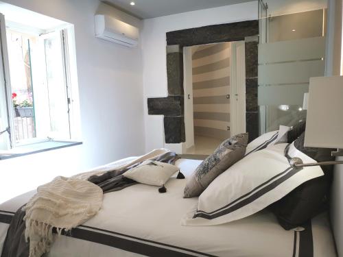 una camera da letto con letto, cuscini e specchio di Vernazza Luxury Apartment a Vernazza