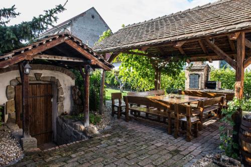 a wooden pavilion with a wooden table and a wooden table at Penzion Monika in Hrušovany nad Jevišovkou