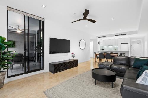 a living room with a couch and a tv at Melbourne Holiday Apartments Flinders Wharf in Melbourne