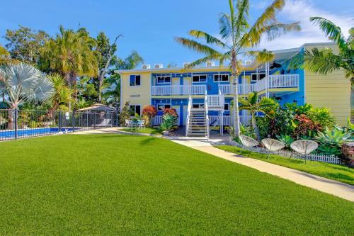 a blue house with a lawn in front of it at Coral Inn Boutique Motel in Yeppoon