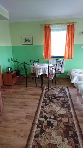 een woonkamer met een tafel en stoelen en een raam bij Hotelik WARMIA -Pensjonat, Hostel in Lidzbark Warmiński