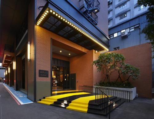 台北的住宿－捷絲旅台北三重館，黄色和黑色走道的建筑的大堂