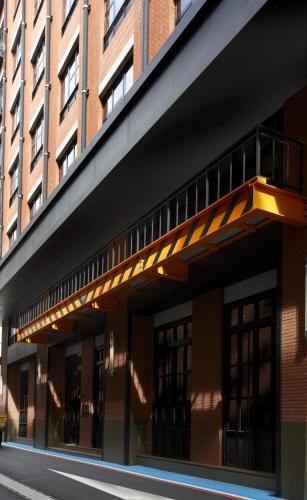 a building with a balcony on the side of it at Just Sleep - Sanchong in Taipei