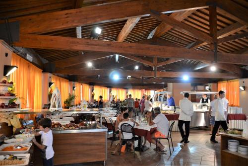 un restaurant avec des personnes assises dans une salle dans l'établissement Residence I Tusci, à Puntone di Scarlino