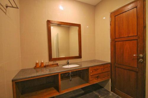 a bathroom with a sink and a mirror at The Kertha Ubud in Ubud