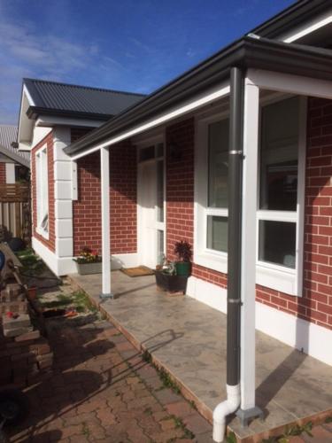 a porch of a house with a brick at Not quite the Ritz in West Richmond