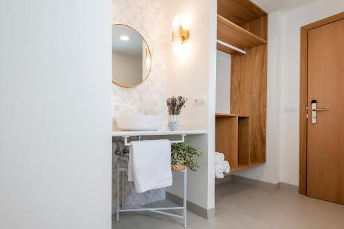 a bathroom with a sink and a mirror at Alzocaire Hostal Boutique in Conil de la Frontera