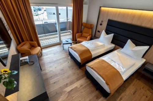 um quarto de hotel com duas camas e uma janela em Augsburg Hotel Sonnenhof em Gersthofen