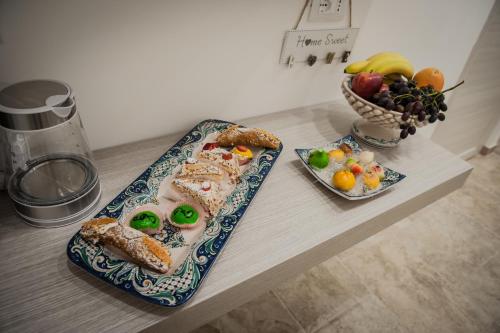 een tafel met twee borden eten en een fruitschaal bij B&B iMori in Caltagirone