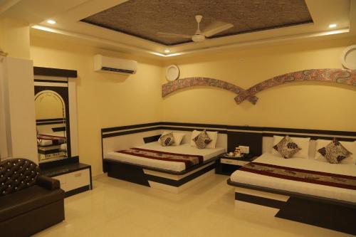 a bedroom with two beds and a mirror at Hotel Royal Ajmer in Ajmer