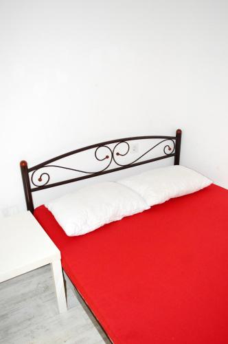 a bed with a red blanket and a white chair at Hostel Train Station in Kyiv