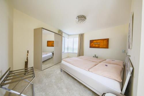 a bedroom with a large bed and a mirror at Country Lake Villa in Breitenbrunn