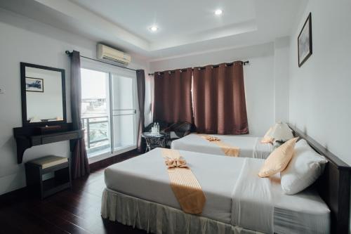 a hotel room with two beds and a window at Iyara Hua Hin Lodge in Hua Hin