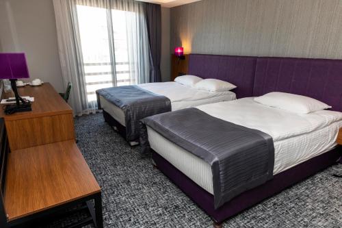 a hotel room with two beds and a desk at BUSINESSPALAS DELUXE in Izmit