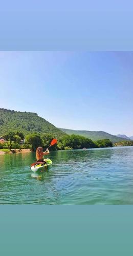 a person on a paddle board in the water at Villa Mirna in Mostar