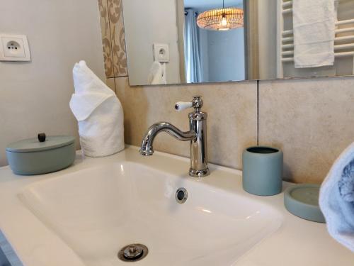 un lavabo de salle de bain avec un robinet et un miroir dans l'établissement Appartement L'Oliveraie - La Cité plein les yeux, à Carcassonne