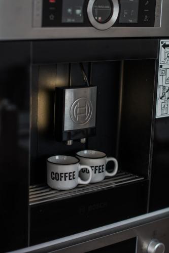 two coffee cups sitting on a shelf in a microwave at Chata Valca PATJA-v mesiacoch apríl až november pri prenajatí aj jedného apartmánu uzavrieme ostatné apartmány, aby ste si užili súkromie in Valča