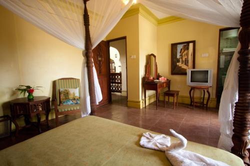 a bedroom with a bed with a swan on it at Asmini Palace Hotel in Zanzibar City