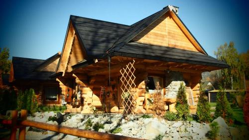a log cabin with a giraffe in front of it at Chata w Rabce - Bajkowa Osada in Rabka