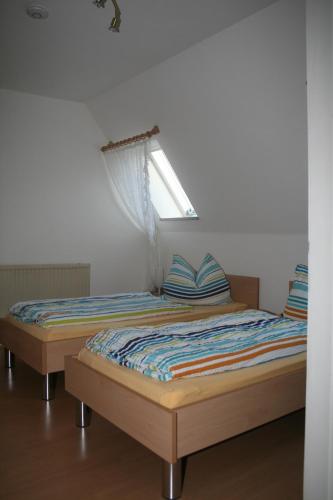 a bedroom with two beds and a window at Ferienwohnung Franken in Fürth