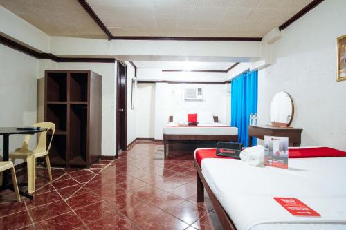 a room with a bedroom with a bed and a table at RedDoorz @Downtown Bacolod in Bacolod