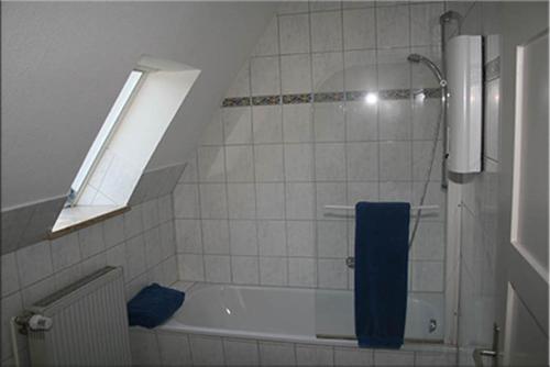 a bathroom with a bath tub with a blue towel at Ferienwohnung Franken in Fürth