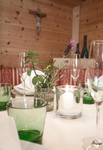 a table with wine glasses and a candle on it at Gasthof Schmalzerhof in Weer