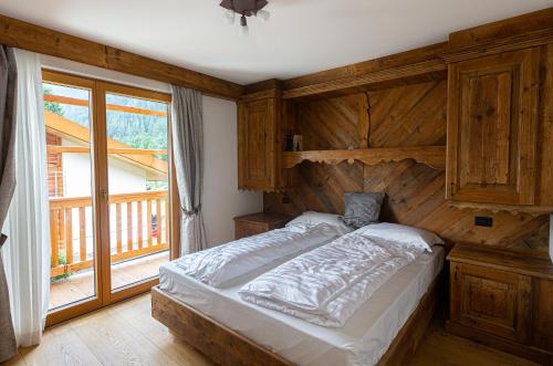 a bedroom with a bed with a wooden wall at Sport Hotel Rudolf in Gressoney-Saint-Jean