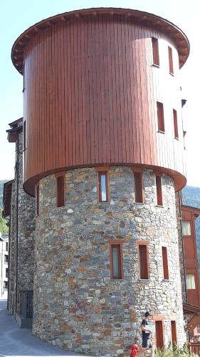 a large stone building with a red roof at SOLDEU cosy home in Soldeu