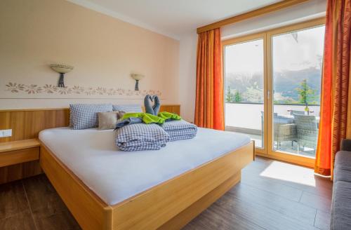 a bedroom with a bed with a large window at Gut Sonnbichl in Ladis