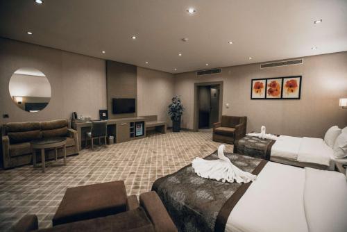 a hotel room with two beds and a living room at Hilly Hotel in Edirne