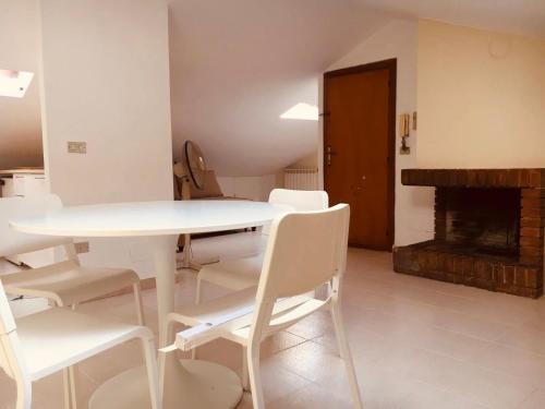 a white table and chairs in a room with a fireplace at Mansardina in centro in Tagliacozzo