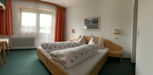 een slaapkamer met een bed met kussens erop bij Landhaus Ahrn in Leutasch