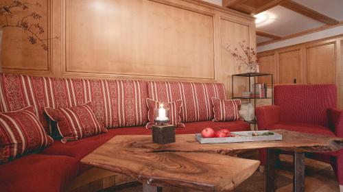 a living room with a red couch and a table at Gasthof Schmalzerhof in Weer