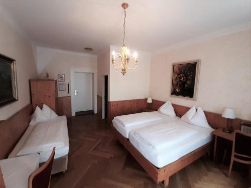 1 Schlafzimmer mit 2 Betten und einem Kronleuchter in der Unterkunft Hotel Lehenerhof in Salzburg