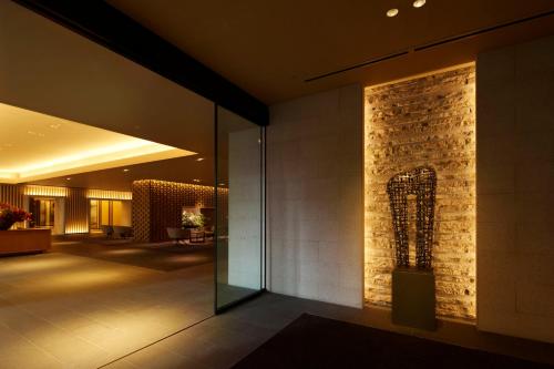 a lobby of a hotel with a stone wall at The Prince Sakura Tower Tokyo, Autograph Collection in Tokyo