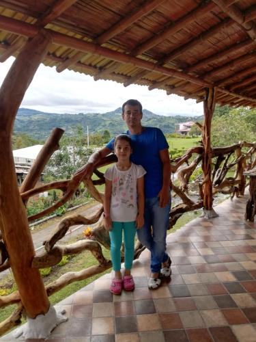 a man and a girl standing under a wooden structure at Cabañas Guacari San Agustín huila in San Agustín