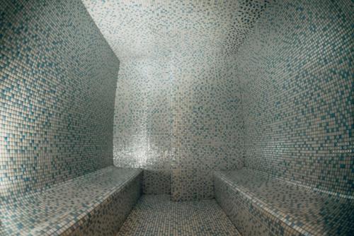 a corner of a bathroom with tiled walls at Hilly Hotel in Edirne