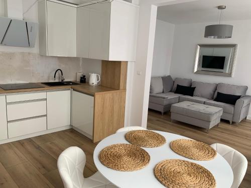 eine Küche und ein Wohnzimmer mit einem weißen Tisch und Stühlen in der Unterkunft Apartament w centrum in Mrągowo