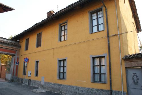 a yellow building with windows on a street at B&B La Braida in Vinovo