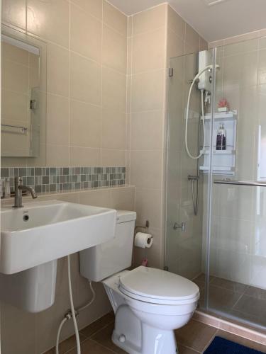 a bathroom with a toilet and a sink and a shower at บ้านเพียงเพลิน in Hua Hin