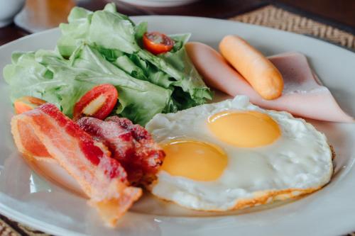 a plate of food with eggs and a salad at Iyara Hua Hin Lodge in Hua Hin