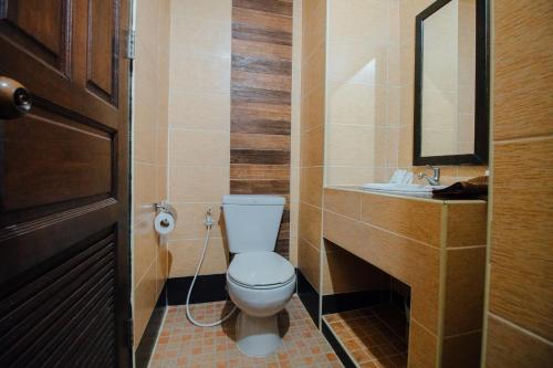 a bathroom with a toilet and a sink at Iyara Hua Hin Lodge in Hua Hin
