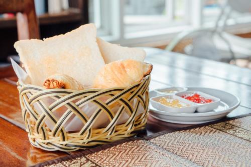 a basket with bread and otheriments on a table at Iyara Hua Hin Lodge in Hua Hin
