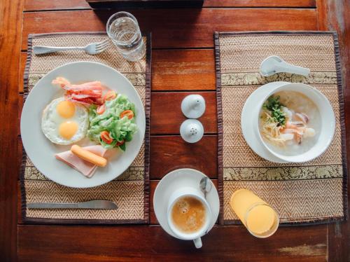 a table with two plates of food and a cup of coffee at Iyara Hua Hin Lodge in Hua Hin
