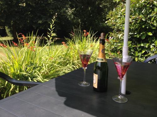 a bottle of wine and two glasses on a table at La Ville de Mainguy in Josselin