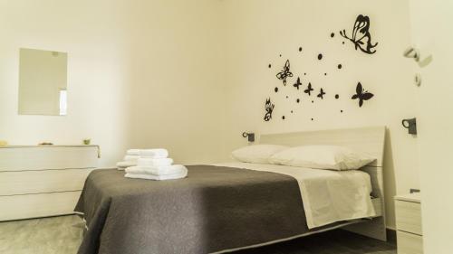 ein Schlafzimmer mit einem Bett mit Schmetterlingen an der Wand in der Unterkunft Il Nido del Gabbiano in Bagheria