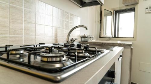 a stove top in a kitchen with a sink at Il Nido del Gabbiano in Bagheria