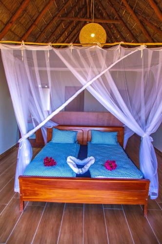 a bed in a room with a canopy at Vilancool Beach Resort in Vilanculos