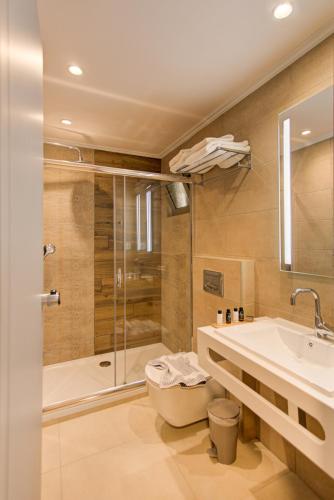 a bathroom with a shower and a sink and a toilet at Maria Beach Hotel in Kissamos